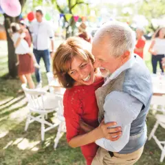 Pareja mayor bailando feliz en una fiesta al aire libre. 30 años de casados que significa: amor, complicidad y alegría compartida.