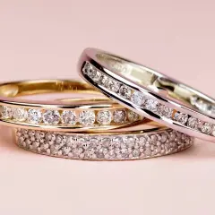 Tres anillos de diamantes apilados, uno de oro amarillo, otro de oro blanco y uno más con doble hilera de gemas. El anillo churumbela significado es de amor eterno.