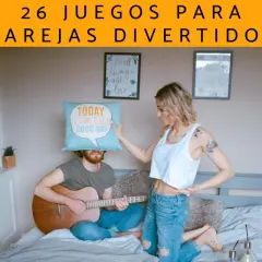 Pareja en cama, él toca guitarra con cojín en la cabeza, ella señala. Ideas de qué hacer con tu novio para no aburrirse.