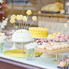 Deliciosa comida para revelación de género: pastel amarillo con lunares, macarons y bocadillos dulces.