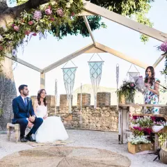 Novia y novio sentados, oficiante leyendo. La decoración floral es exuberante. ¿Cuánto dura una boda civil? Depende de la ceremonia.