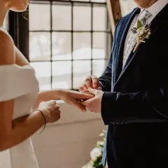 Novio pone anillo a novia. Un juez o funcionario civil es quien puede oficiar una boda civil.