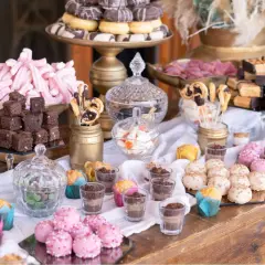 Mesa dulce casera para boda: brownies, malvaviscos rosas, donuts, pastelitos y más.