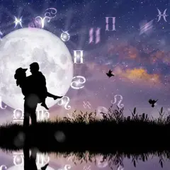 Silueta de pareja abrazada bajo la luna llena, rodeada de símbolos zodiacales. Una escena que evoca la compatibilidad signos zodiaco y el romance cósmico.