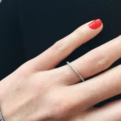 Anillo de diamantes finos, perfecto para frases para alianzas que sellan un amor eterno. Uñas rojas vibrantes.