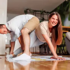 Pareja riendo mientras juega Twister, un divertido juego para jugar en pareja.