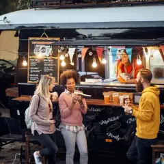 Gente disfrutando de comida deliciosa de food trucks.