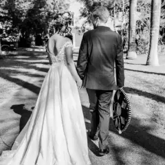 Novios caminando de la mano, ella con vestido de novia y él con traje y sombrero charro. Un recuerdo para todos los nombres de aniversarios de boda.