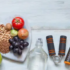 Alimentos saludables y equipo de ejercicio, como una cuerda de saltar y un expansor de mano, para tu motivación personal.