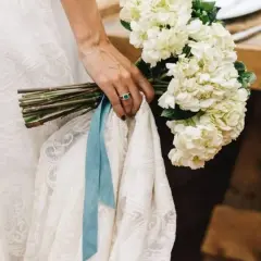 Novia con ramo de hortensias blancas y algo azul: una cinta de seda y un anillo esmeralda.