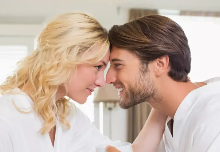 Una pareja se mira tiernamente, frentes juntas. Ella rubia, él moreno. Quizás ella busca en él la ternura que busca una mujer en un hombre.