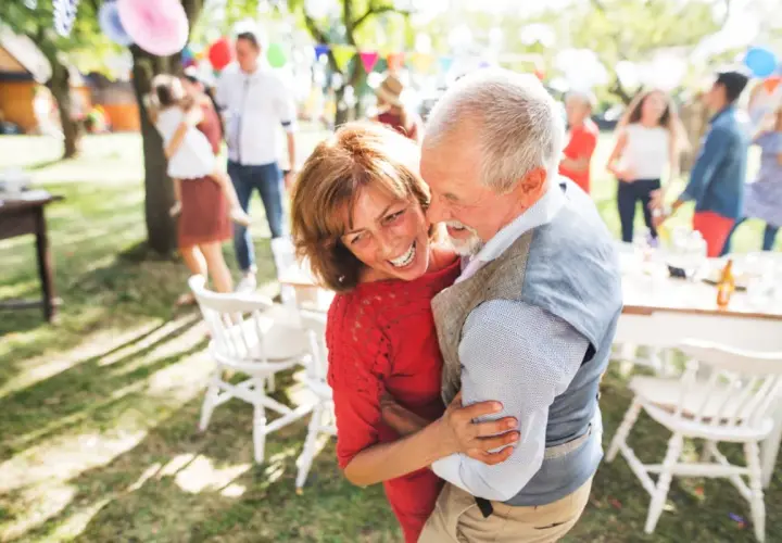 Pareja mayor bailando feliz en una fiesta al aire libre. 30 años de casados que significa: amor, complicidad y alegría compartida.