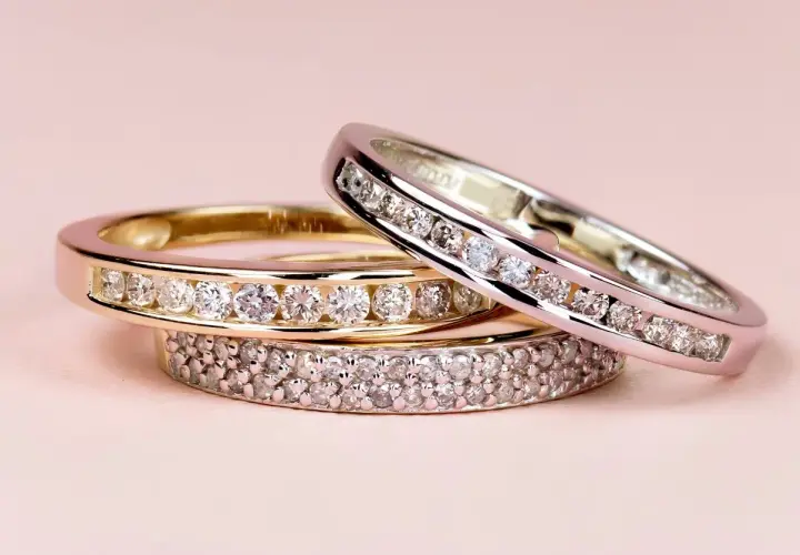Tres anillos de diamantes apilados, uno de oro amarillo, otro de oro blanco y uno más con doble hilera de gemas. El anillo churumbela significado es de amor eterno.