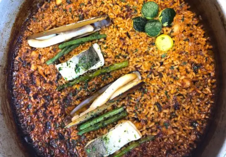 Paella con mariscos, espárragos y pescado. El fondo dorado y crujiente es el socarrat que es la parte más sabrosa.