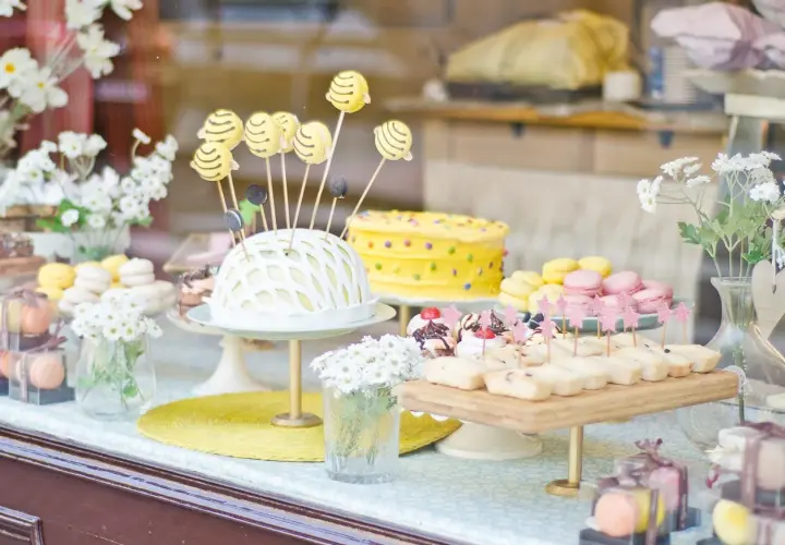 Deliciosa comida para revelación de género: pastel amarillo con lunares, macarons y bocadillos dulces.