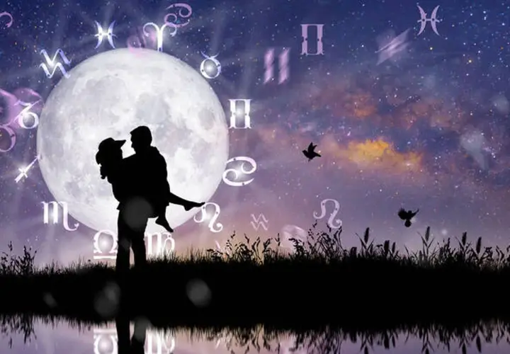 Silueta de pareja abrazada bajo la luna llena, rodeada de símbolos zodiacales. Una escena que evoca la compatibilidad signos zodiaco y el romance cósmico.