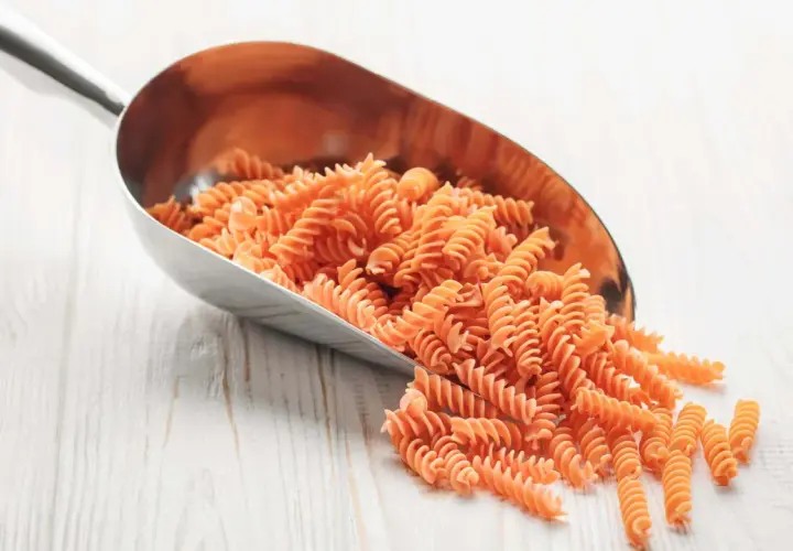 Cuchara metálica llena de macarrones integrales. Ideal para saber como calcular los macarrones por persona y planificar tus comidas.