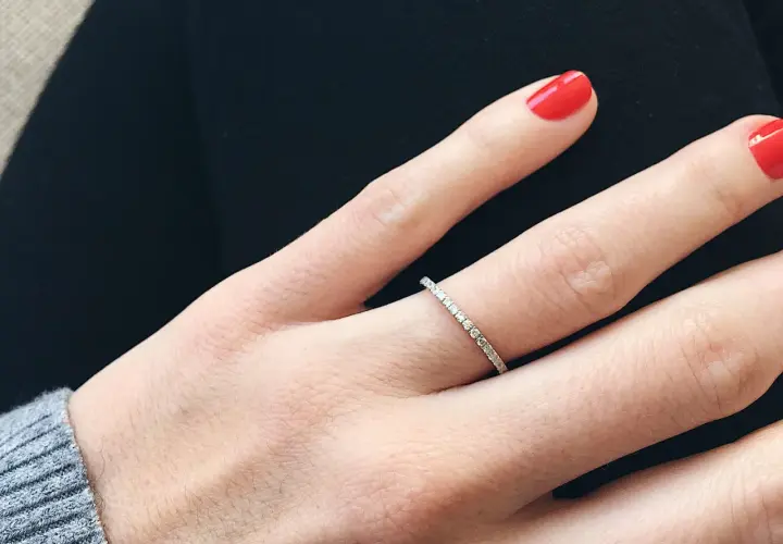 Anillo de diamantes finos, perfecto para frases para alianzas que sellan un amor eterno. Uñas rojas vibrantes.