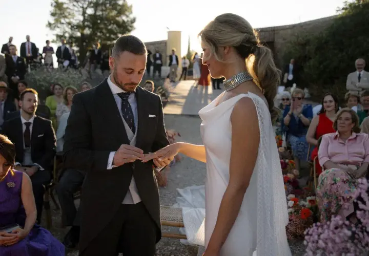 Novio pone anillo a novia. Un momento íntimo que simboliza los beneficios de casarse: amor, compromiso y una vida compartida.