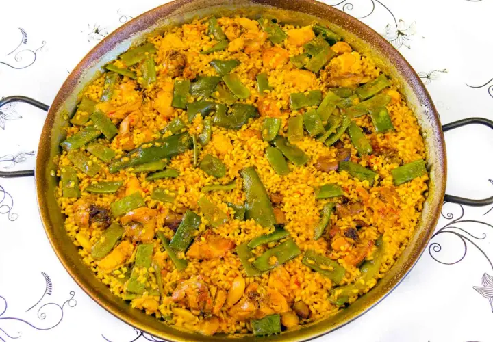 Paella de pollo y judías verdes, un plato que demuestra ser el mejor arroz para paella, con granos dorados y sabrosos.