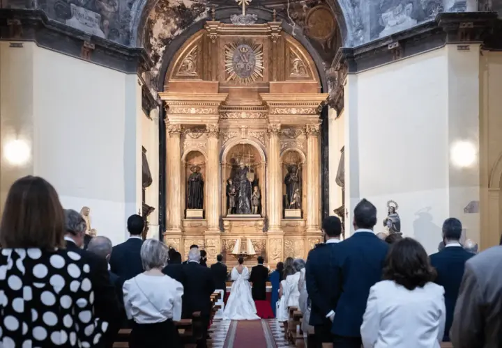 Novios frente al altar, invitados observan. Cumpliendo los requisitos para casarse por la iglesia, un día especial.