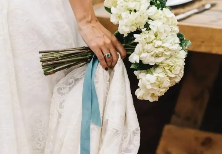 Novia con ramo de hortensias blancas y algo azul: una cinta de seda y un anillo esmeralda.
