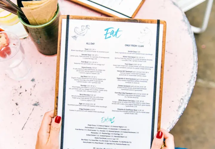Un menú de restaurante con opciones para un menú para bautizo. Incluye platos como tostadas, ensaladas y sándwiches.