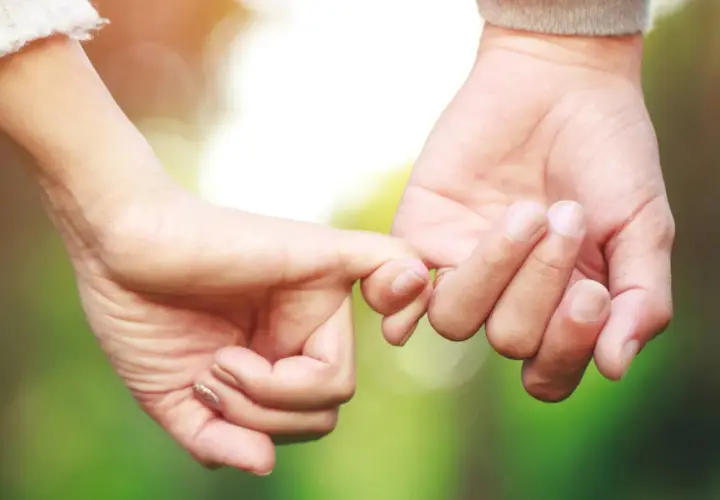Manos entrelazadas, un símbolo de amor y compromiso. Inspiración para frases de parejas exitosas que construyen un futuro juntos.