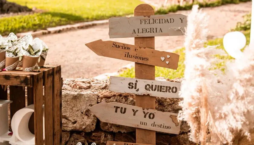 Señalización rústica con frases románticas como "Sí, quiero" y "Tu y yo, un destino". Ideas para rincones de boda.