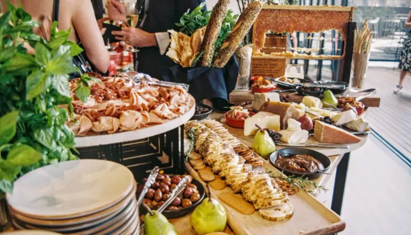 Bandeja de charcutería y quesos, con panes y frutas. ¡Ideas de catering para un evento especial!