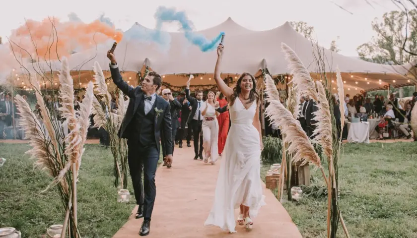 La entrada de los novios al banquete, con bengalas de humo naranja y azul, marca el inicio de la celebración.