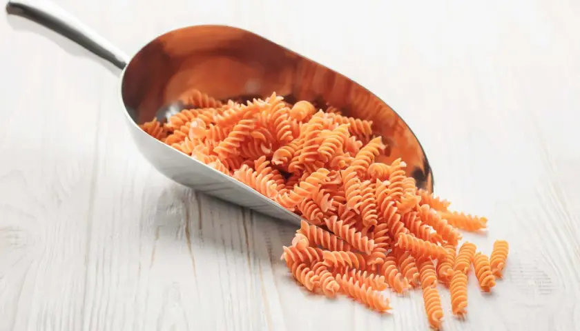 Cuchara metálica llena de macarrones integrales. Ideal para saber como calcular los macarrones por persona y planificar tus comidas.