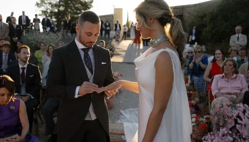 Novio pone anillo a novia. Un momento íntimo que simboliza los beneficios de casarse: amor, compromiso y una vida compartida.