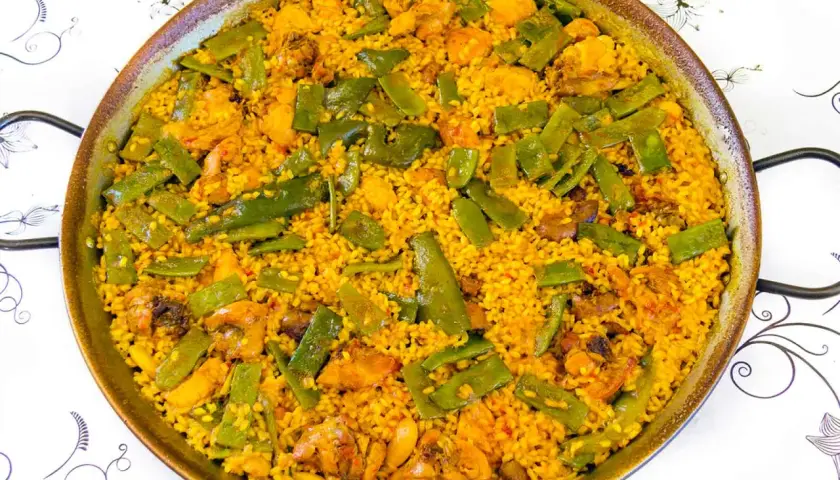 Paella de pollo y judías verdes, un plato que demuestra ser el mejor arroz para paella, con granos dorados y sabrosos.