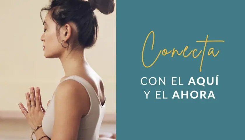Mujer meditando con las manos juntas, practicando mindfulness ejercicios para conectar con el aquí y el ahora.
