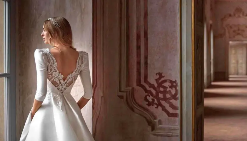 Novia con velo y vestido de encaje, contemplando diferentes tipos de boda en un palacio.