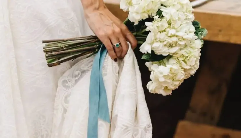 Novia con ramo de hortensias blancas y algo azul: una cinta de seda y un anillo esmeralda.