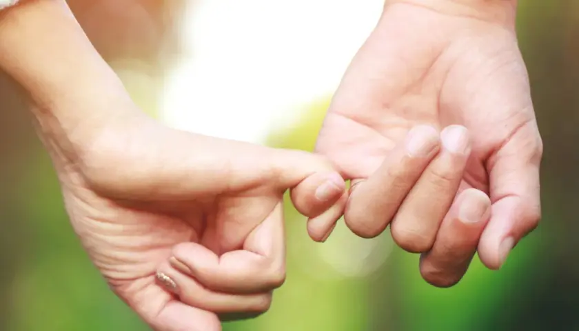 Manos entrelazadas, un símbolo de amor y compromiso. Inspiración para frases de parejas exitosas que construyen un futuro juntos.
