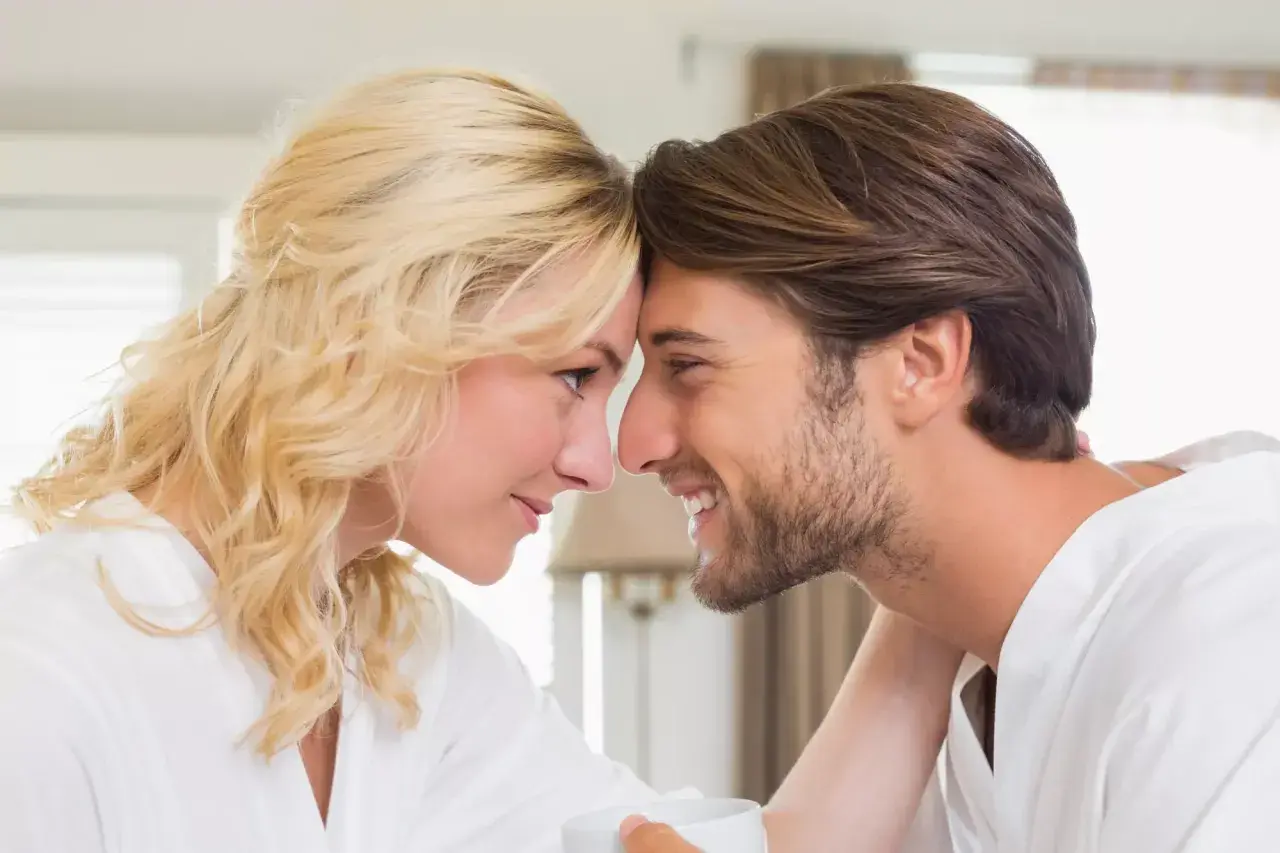 Una pareja se mira tiernamente, frentes juntas. Ella rubia, él moreno. Quizás ella busca en él la ternura que busca una mujer en un hombre.