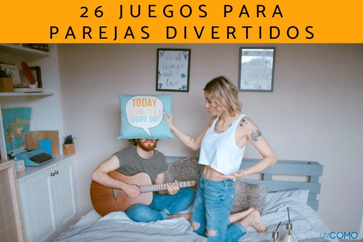 Pareja en cama, él toca guitarra con cojín en la cabeza, ella señala. Ideas de qué hacer con tu novio para no aburrirse.