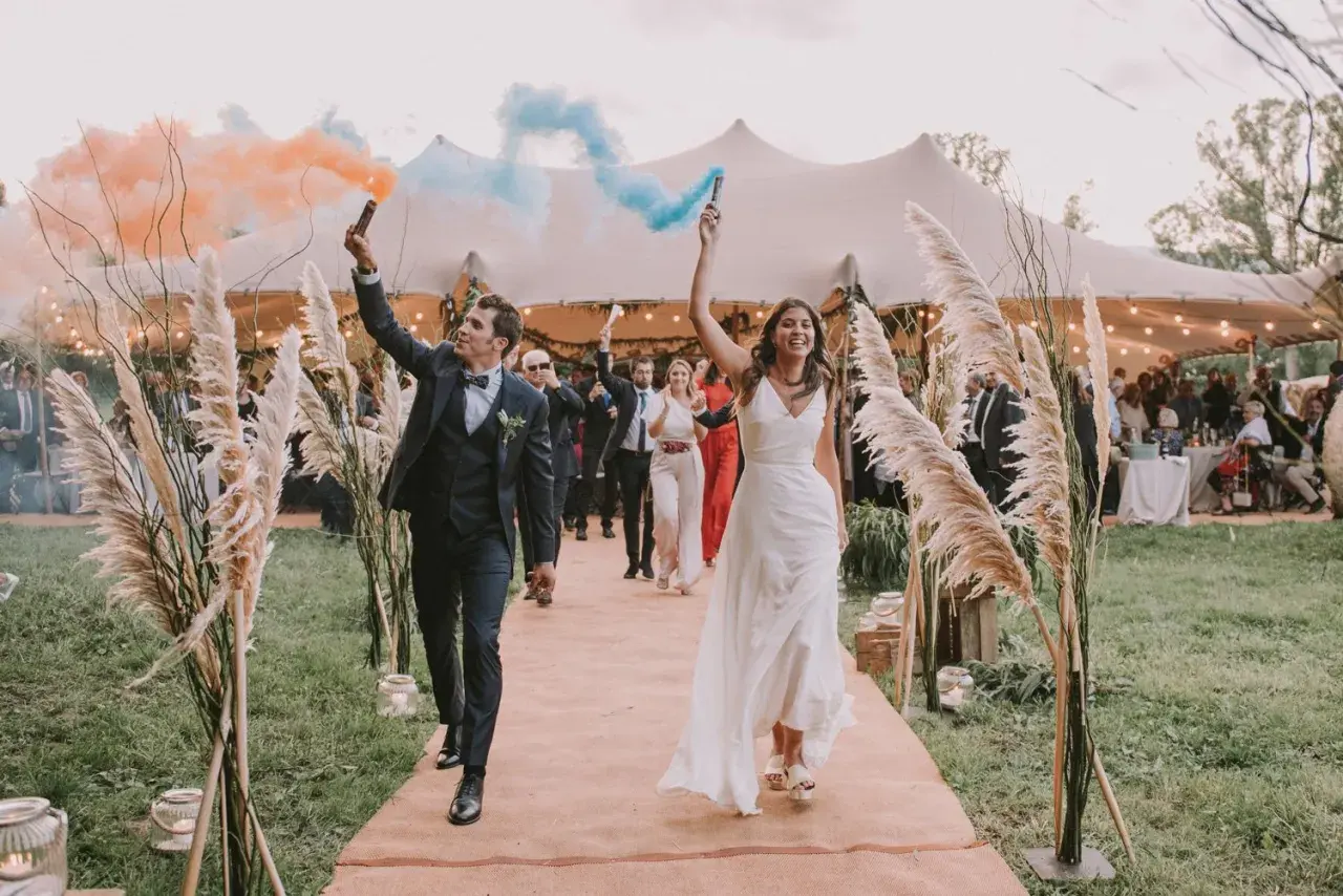 La entrada de los novios al banquete, con bengalas de humo naranja y azul, marca el inicio de la celebración.