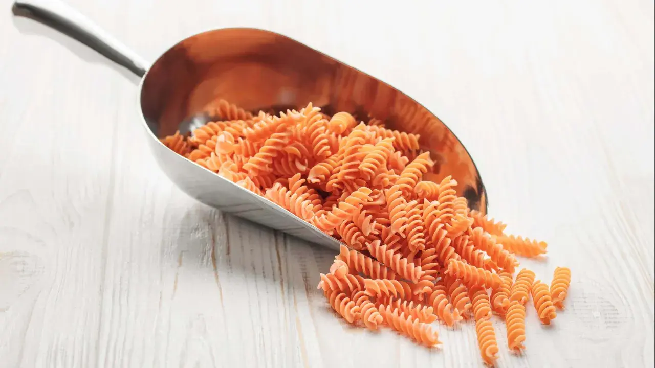 Cuchara metálica llena de macarrones integrales. Ideal para saber como calcular los macarrones por persona y planificar tus comidas.
