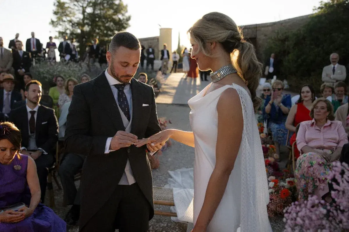 Novio pone anillo a novia. Un momento íntimo que simboliza los beneficios de casarse: amor, compromiso y una vida compartida.