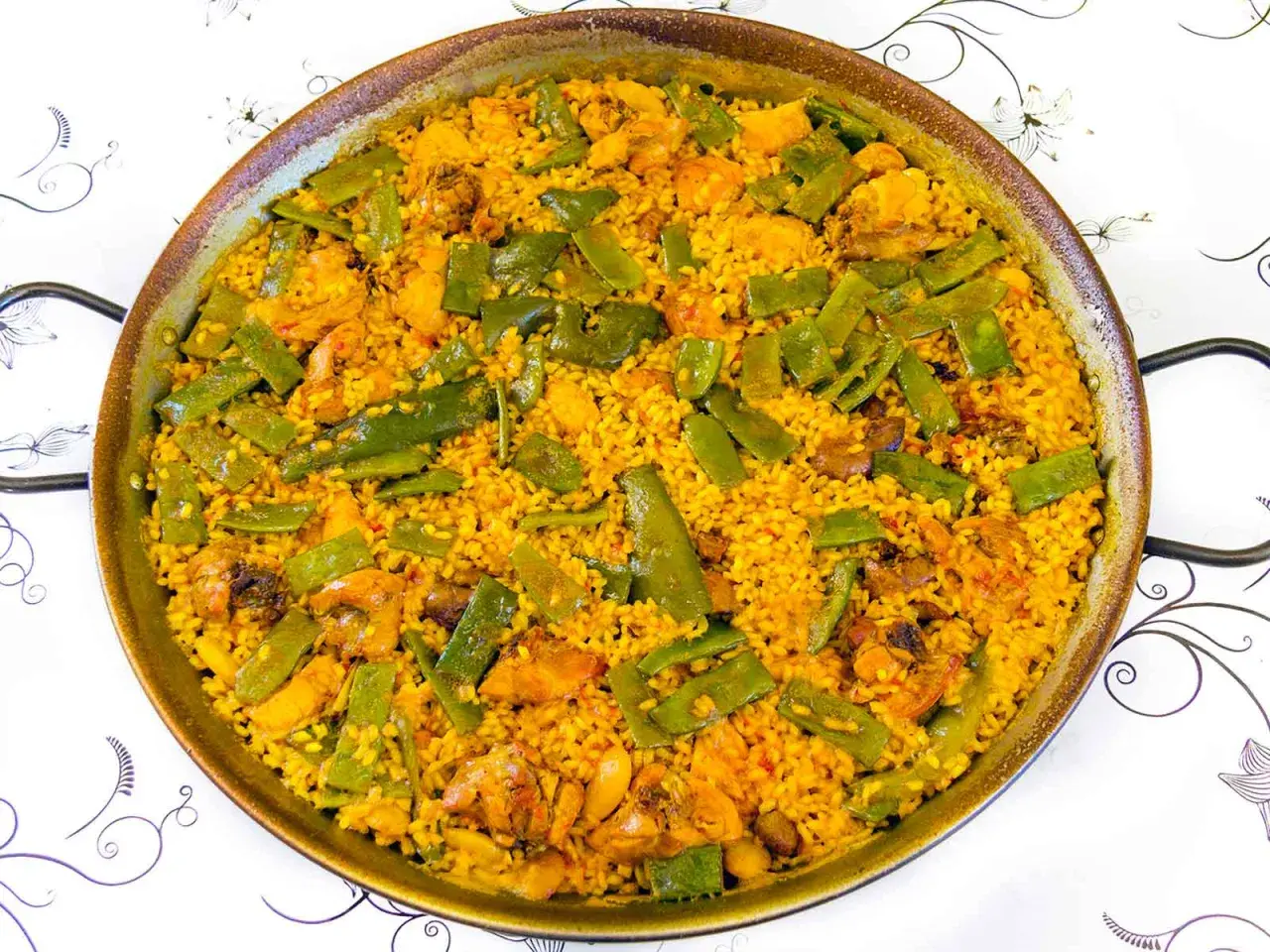 Paella de pollo y judías verdes, un plato que demuestra ser el mejor arroz para paella, con granos dorados y sabrosos.