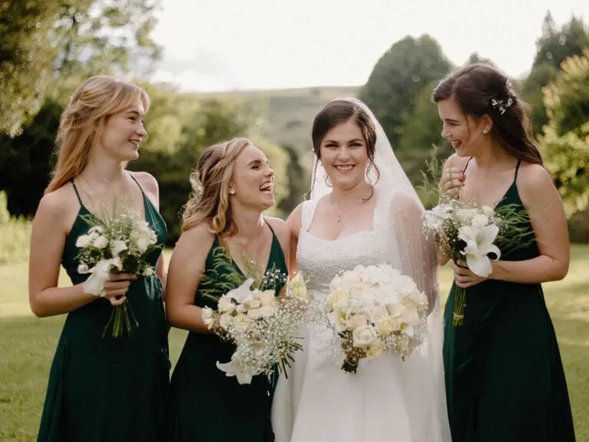 Novia sonriente con damas de honor, un momento perfecto para una boda de tarde.