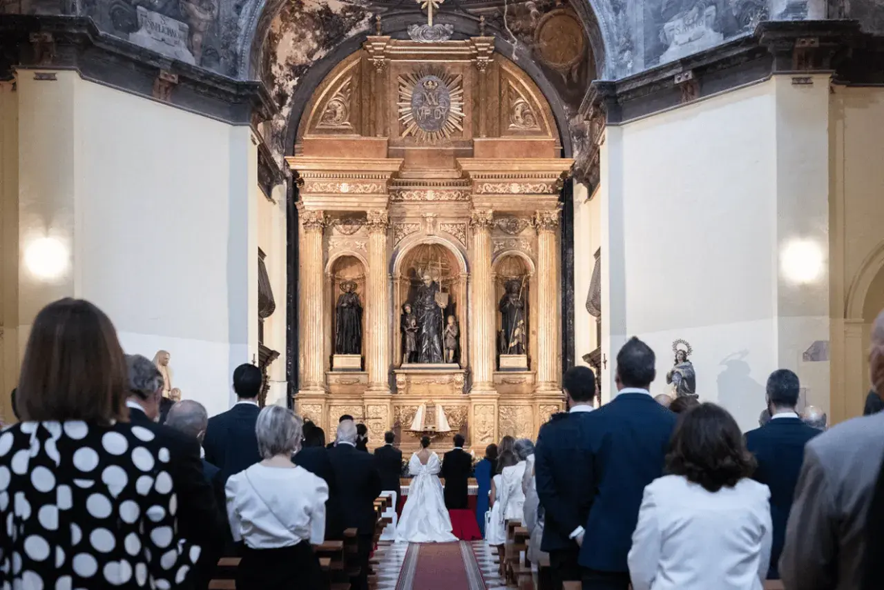 Novios frente al altar, invitados observan. Cumpliendo los requisitos para casarse por la iglesia, un día especial.