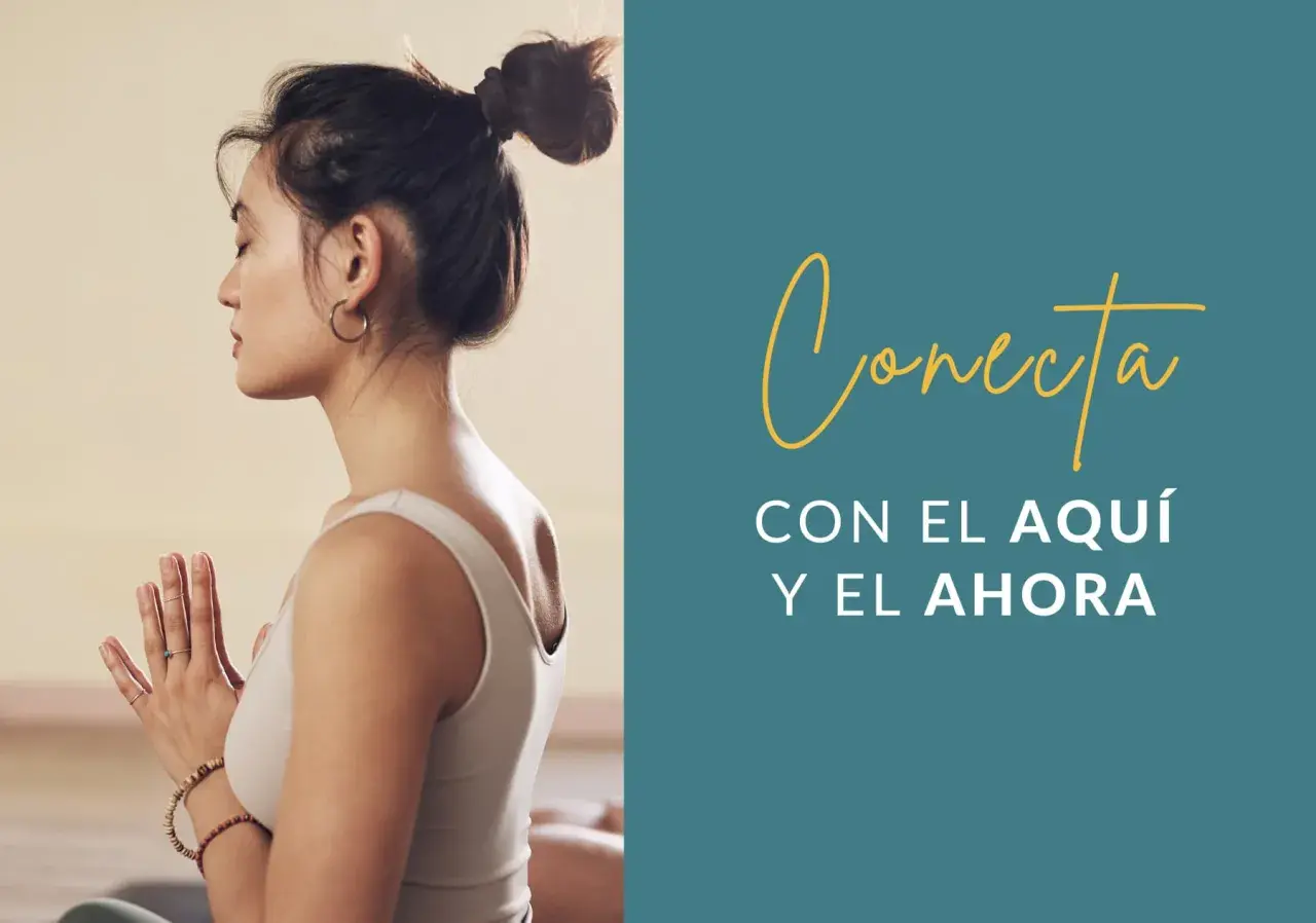 Mujer meditando con las manos juntas, practicando mindfulness ejercicios para conectar con el aquí y el ahora.
