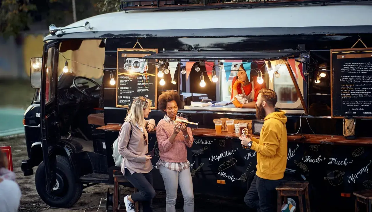 Gente disfrutando de comida deliciosa de food trucks.