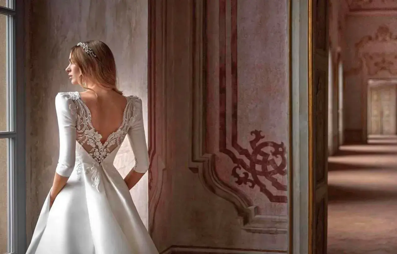 Novia con velo y vestido de encaje, contemplando diferentes tipos de boda en un palacio.
