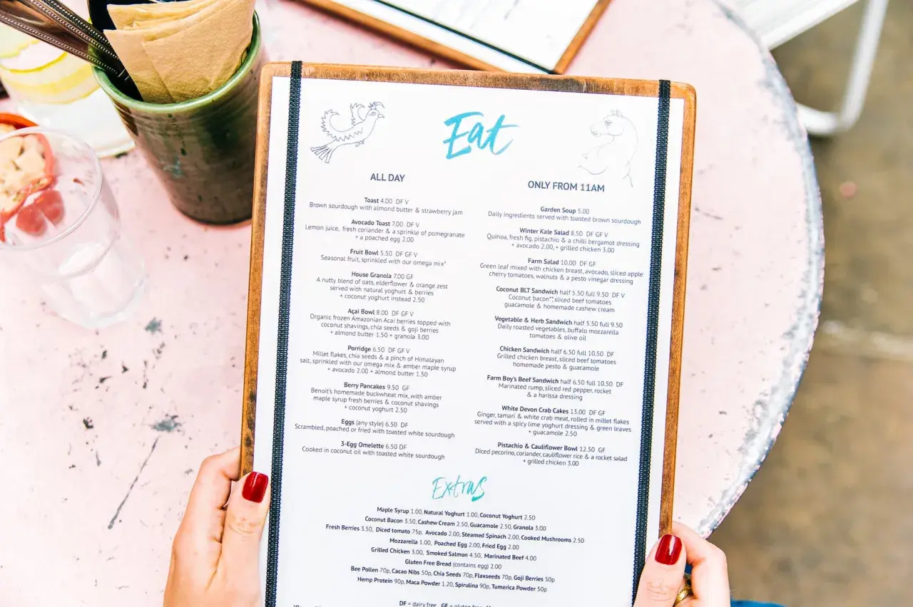 Un menú de restaurante con opciones para un menú para bautizo. Incluye platos como tostadas, ensaladas y sándwiches.